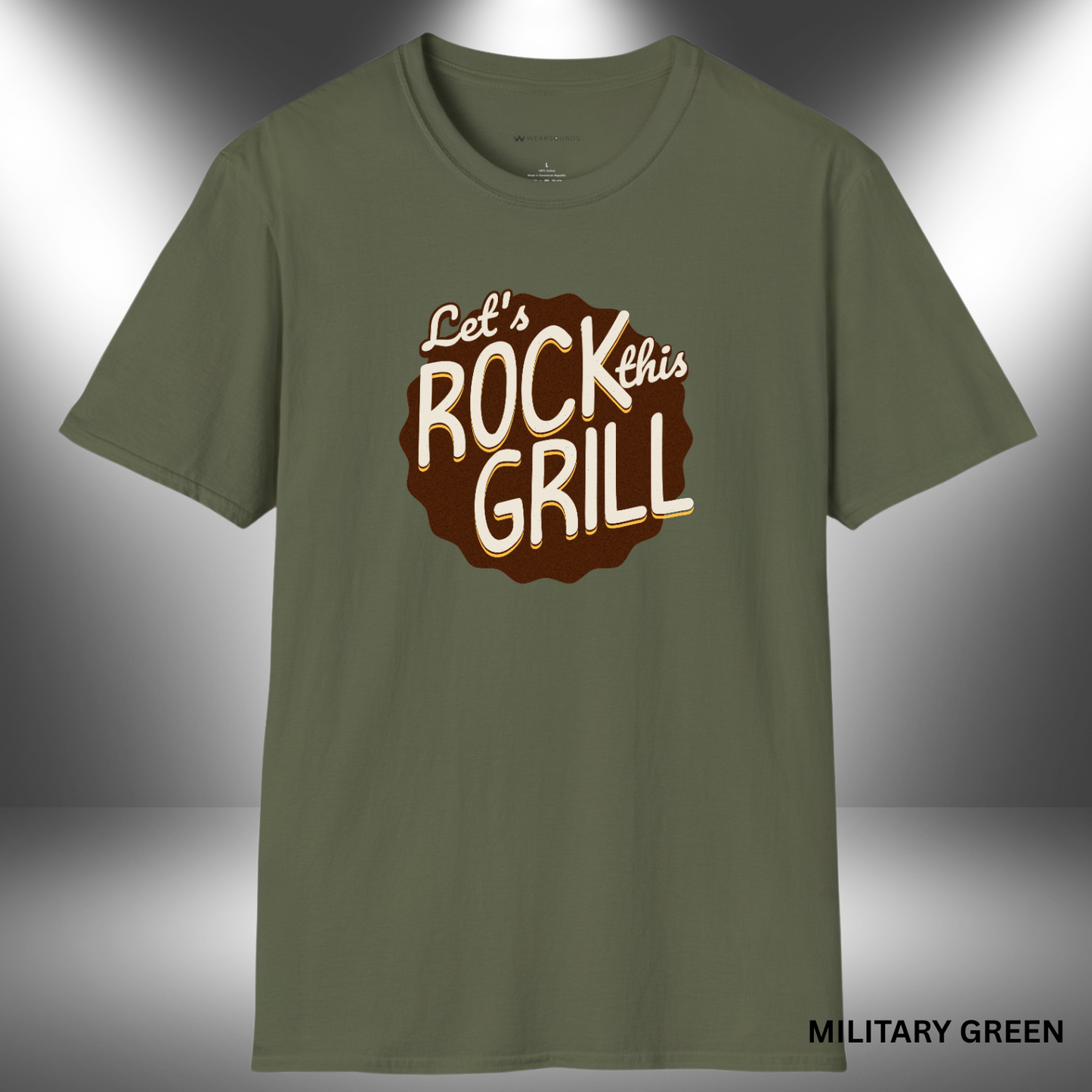 Retro-styled t-shirt graphic with the phrase “Let’s Rock This Grill” in hand-lettered cream and gold text on a dark brown, scalloped badge shape.